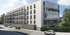 Die Fassade des neuen Mehrfamilienhauses zeigt eine Kombination aus Stein und Glas, ideal für städtisches Wohnen.