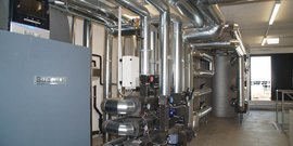 Ein technischer Raum mit einer komplexen Anordnung von Rohren und einem Heizgerät, das für effiziente Wärme sorgt.