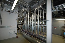 Ein komplexes Rohrleitungssystem mit mehreren Ventilen und Rohren, das in einem industriellen Raum installiert ist.