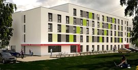 Ein modernes, mehrstöckiges Gebäude mit bunten Fenstern und einer roten Veranda, umgeben von einer grünen Wiese.