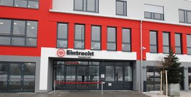 Eingang des Eintracht Frankfurt Gebäudes mit einem Willkommensschild und einer roten Absperrung vor der Tür.