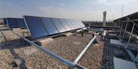 Auf dem Dach sind mehrere Solarpanels installiert, die in der Sonne glänzen, um erneuerbare Energie zu erzeugen.